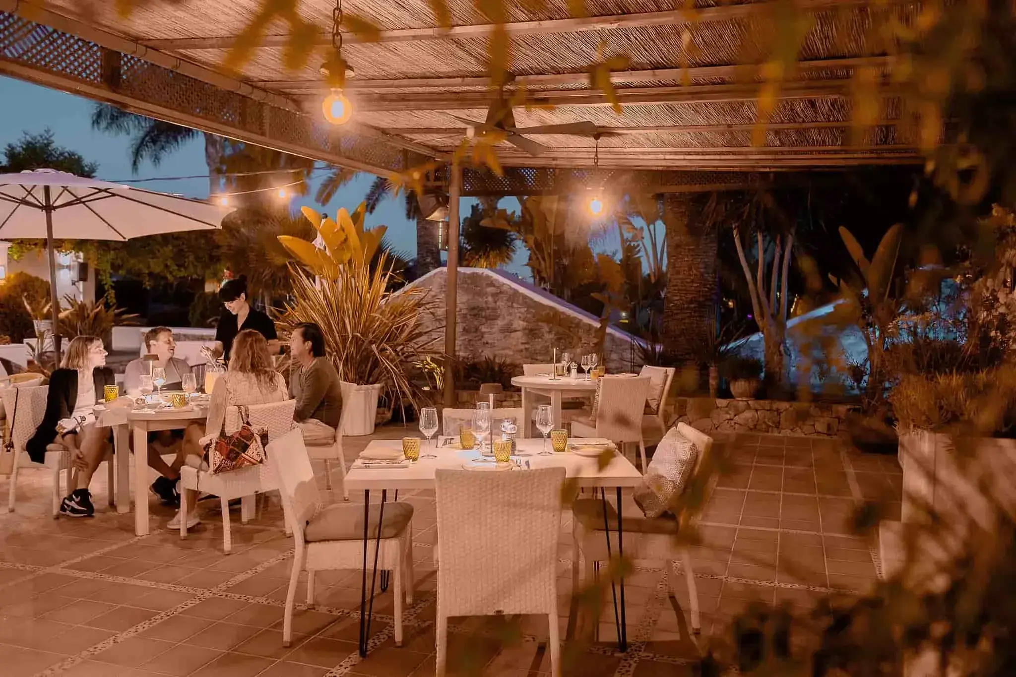 Es Jardins de Fruitera: Garden terrace with tables lit at night