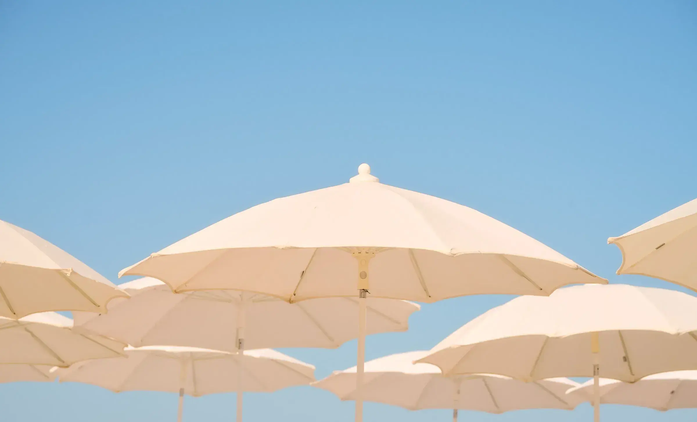 Experimental Beach: Cream beach umbrellas against the sky