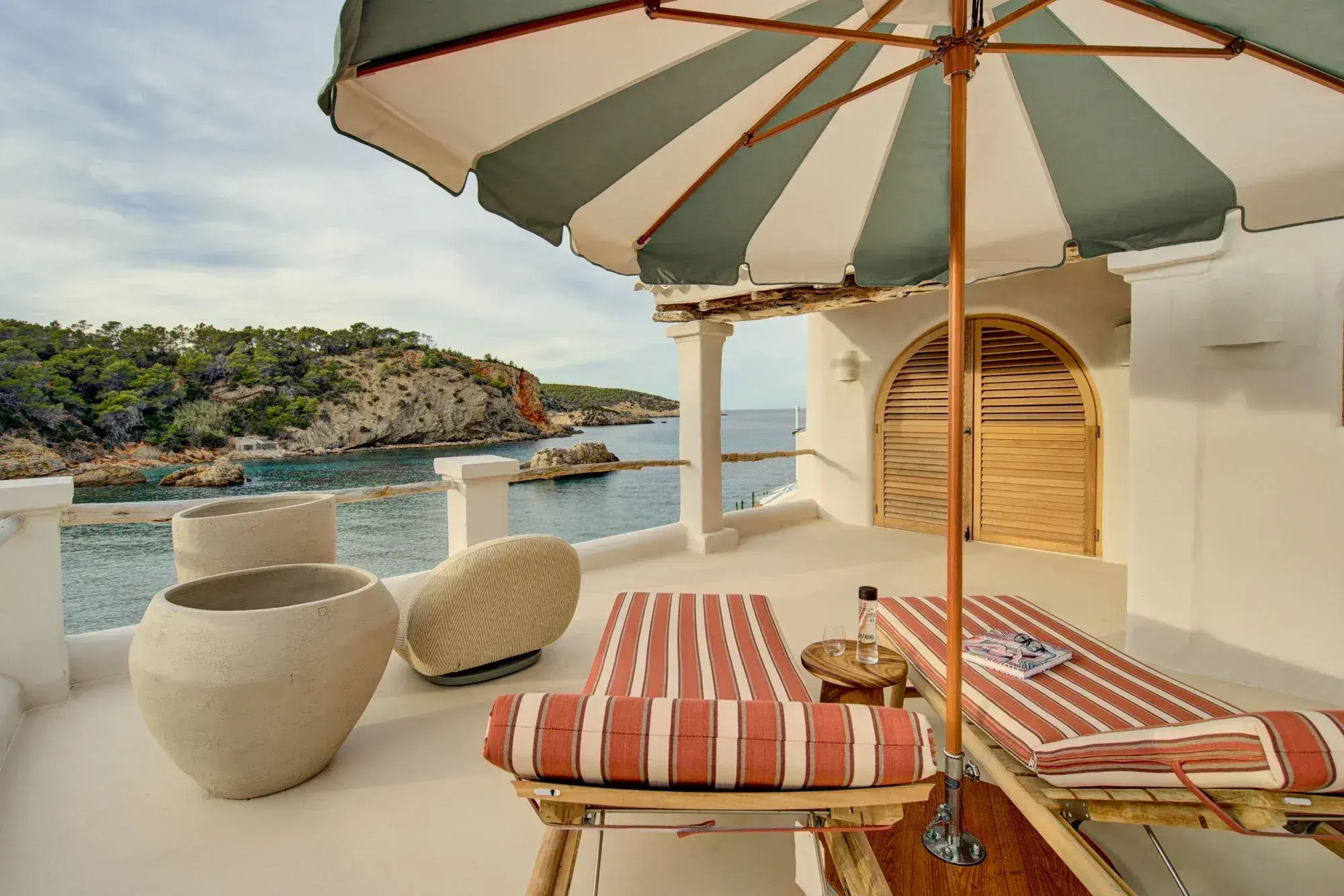 Fincadelica Xarraca: Terrace with striped parasol and loungers over the bay