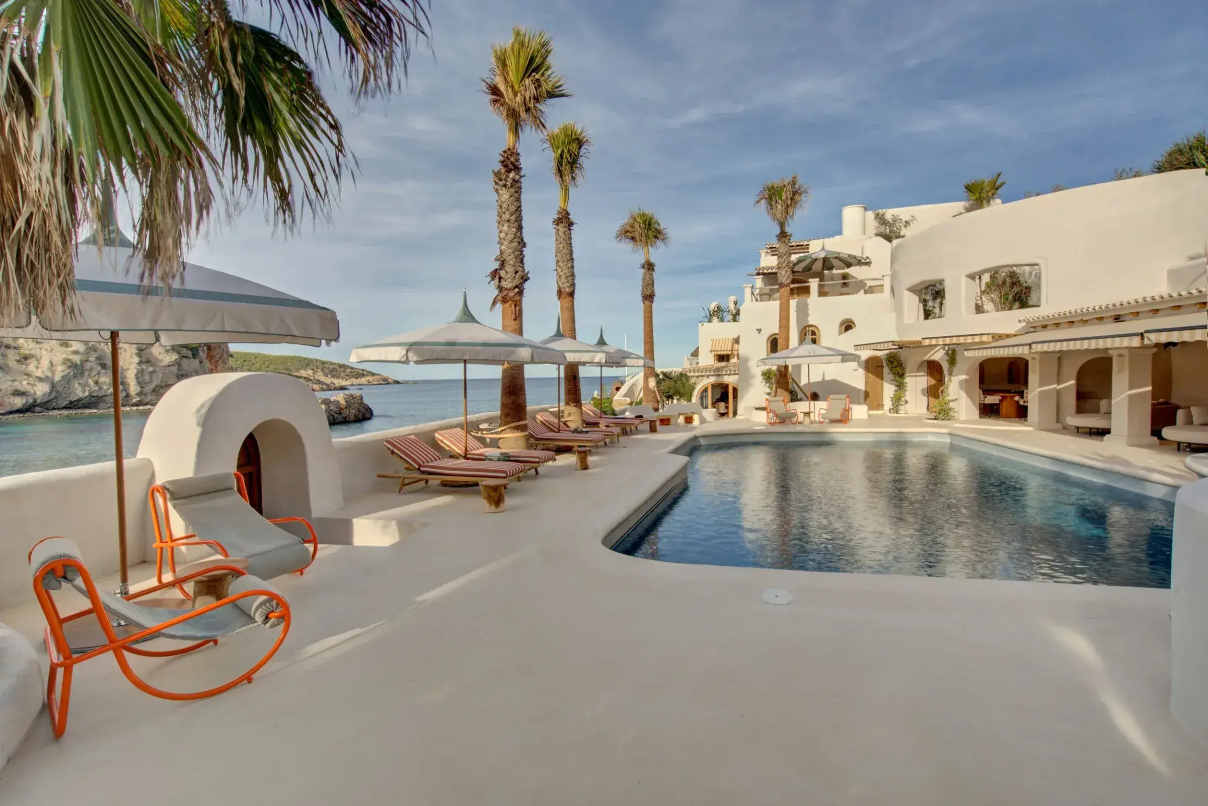 Fincadelica Xarraca: Pool terrace lined with palms and white buildings