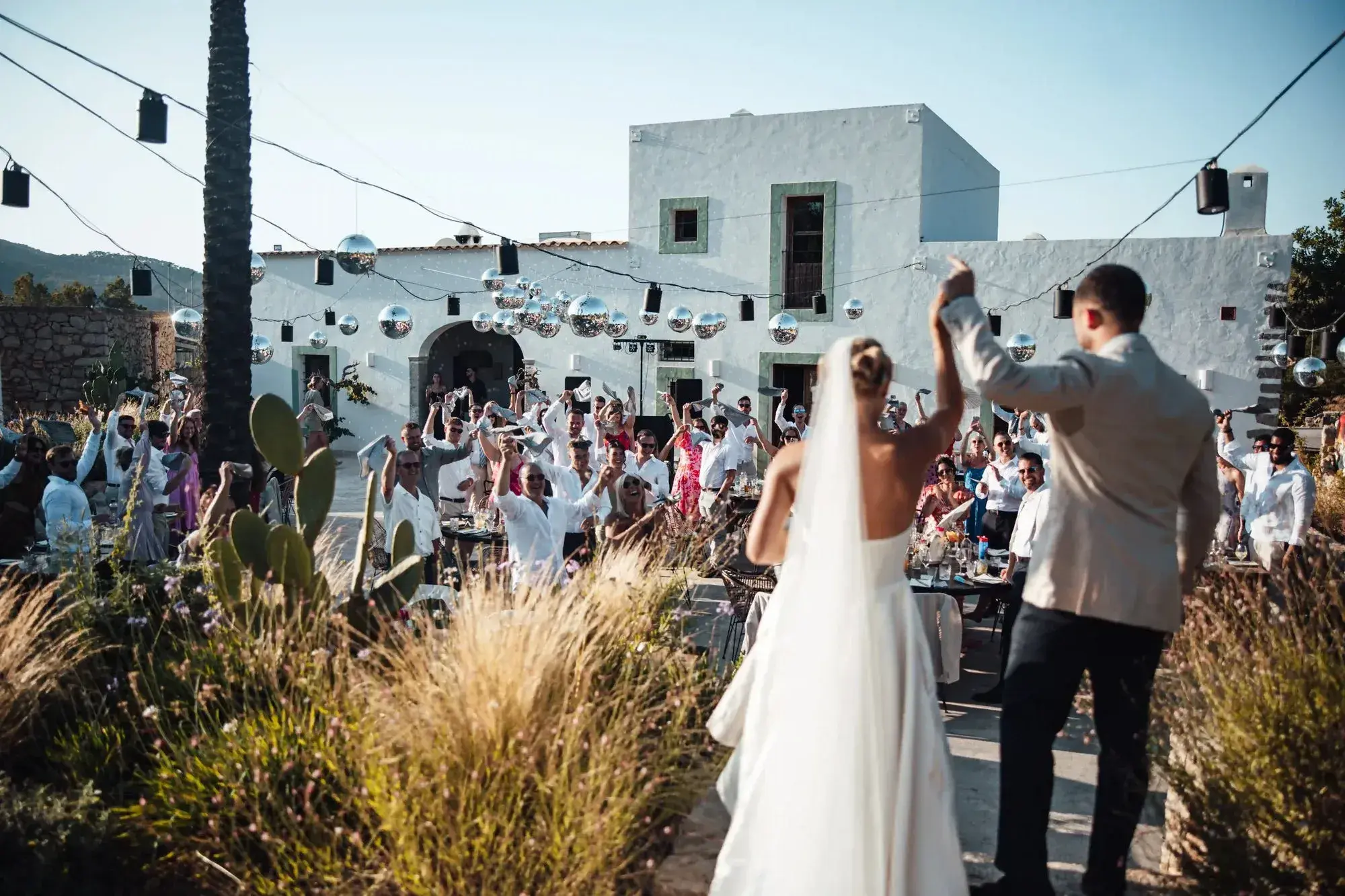 Juntos House: Bride and groom celebrating with guests in the courtyard in front of the house