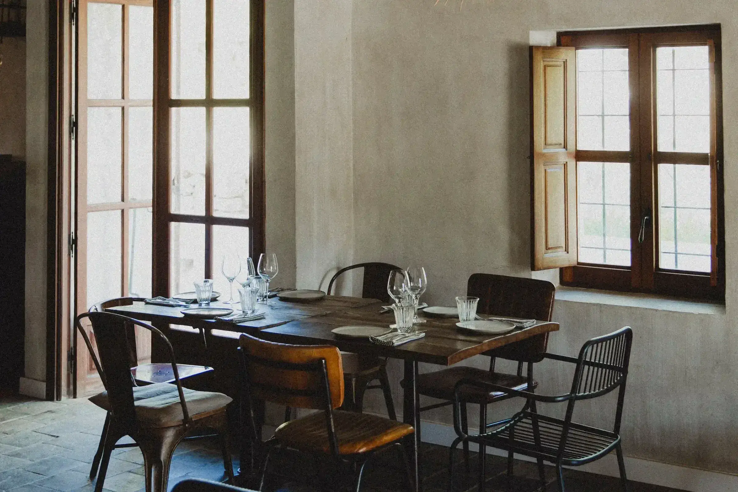 Juntos House: Dining room with wooden tables and tall shuttered windows