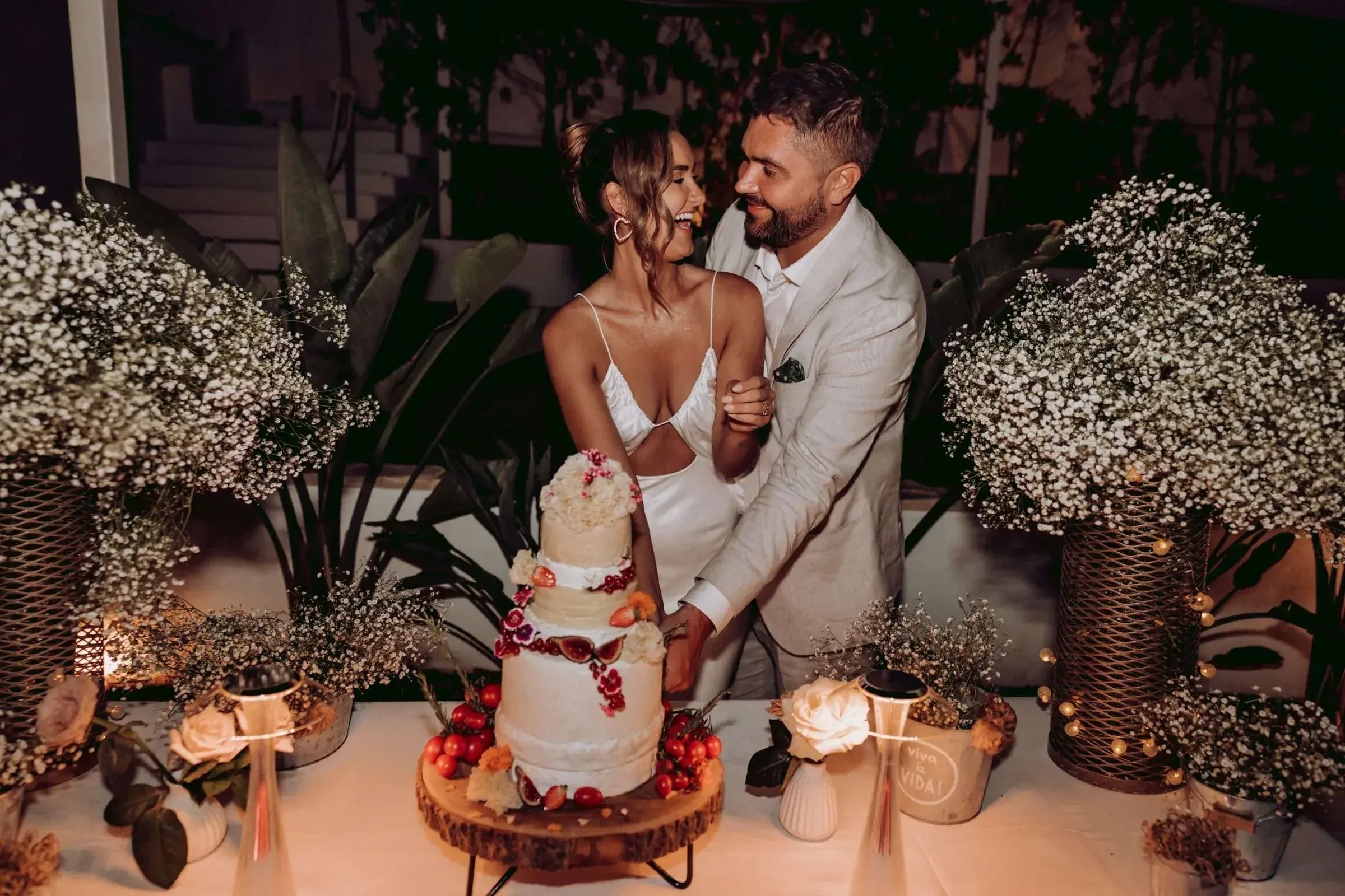 Kazamor: Couple cutting the cake between gypsophila arrangements