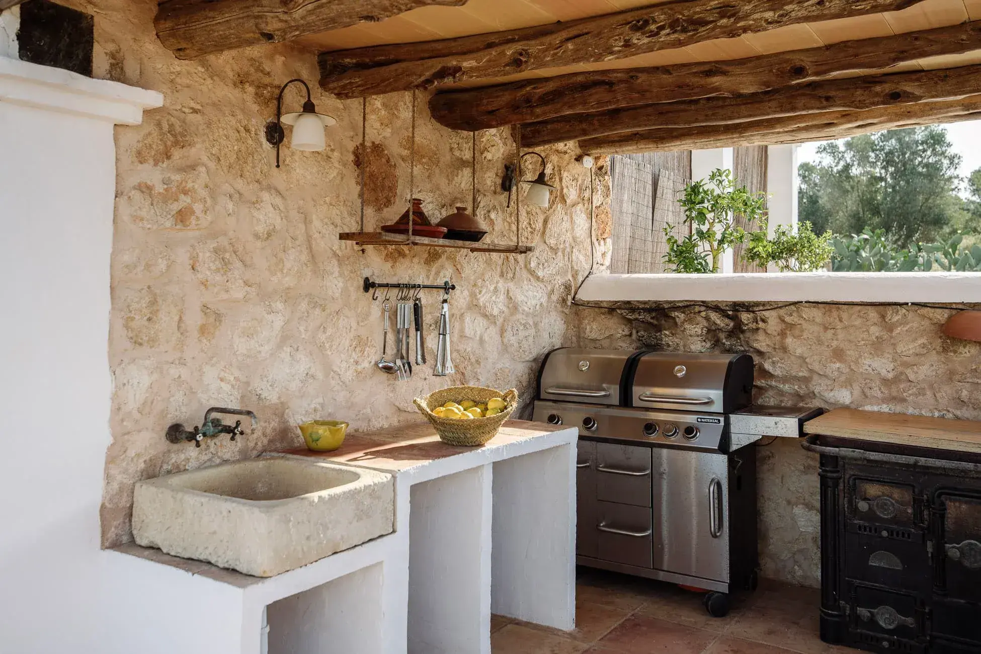 Las Cicadas: Outdoor kitchen with stone walls and beamed ceiling