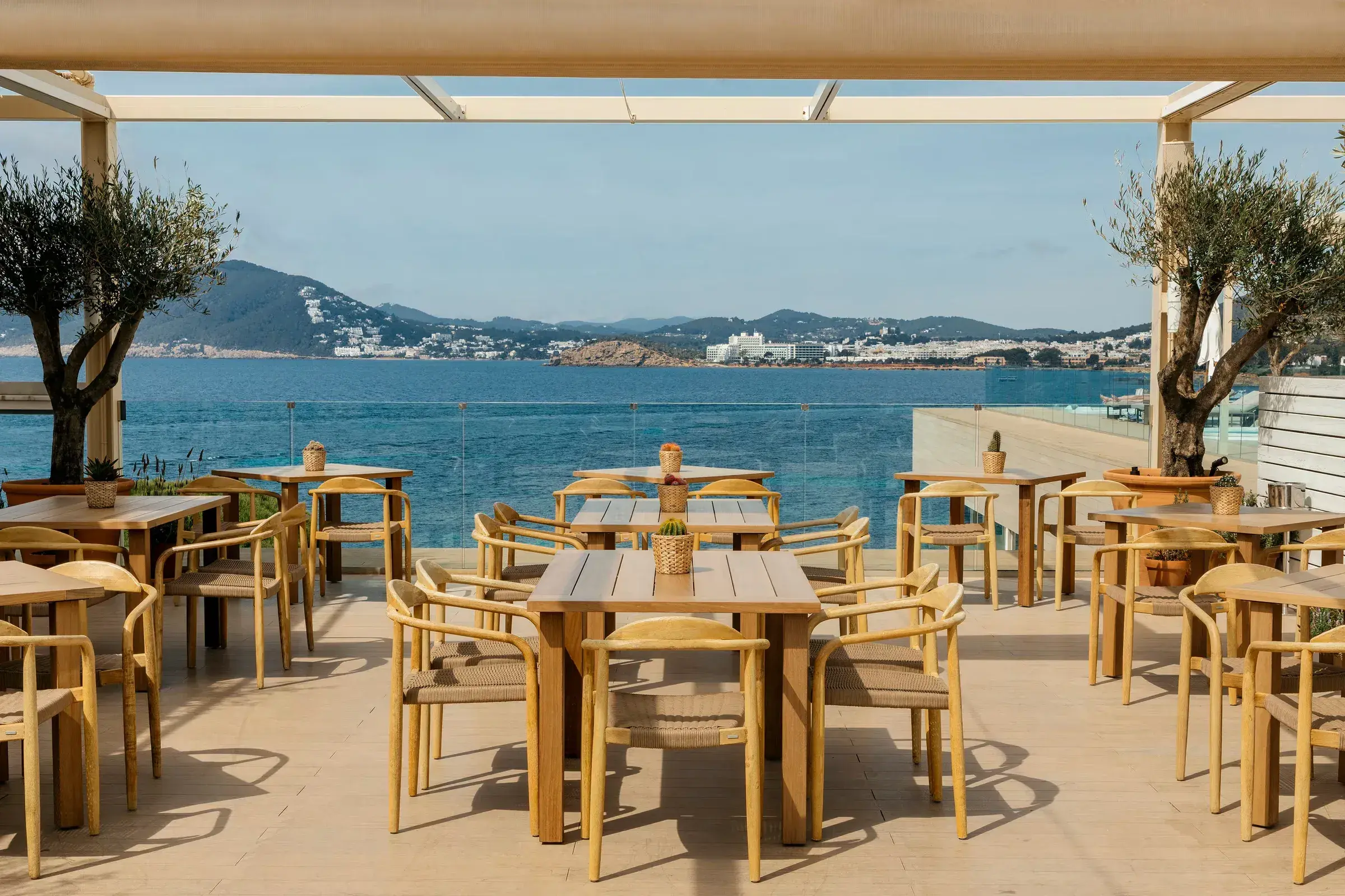 ME Ibiza: Seafront terrace with wooden tables facing Santa Eulalia bay