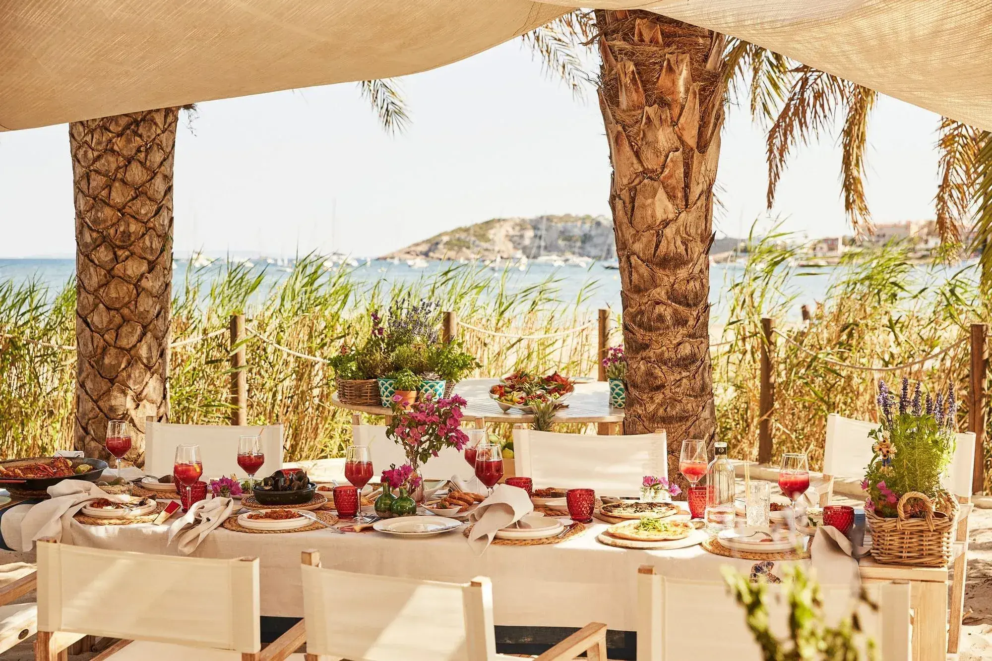 Nobu Hotel Ibiza Bay: Shaded beach dining table under palm trees and a sailcloth canopy