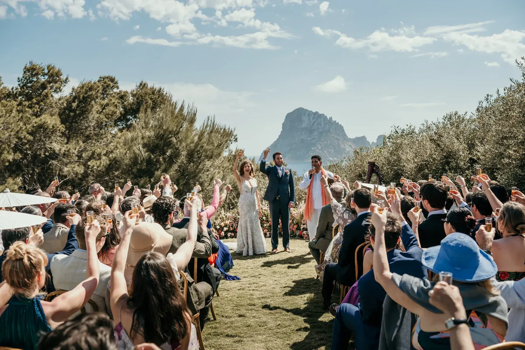 Guests cheering the couple at a ceremony facing Es Vedrà at Petunia Ibiza