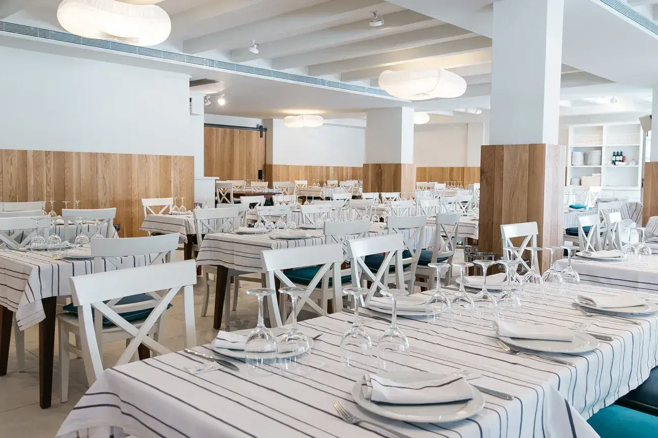 Port Balansat: Bright indoor dining hall with striped tablecloths