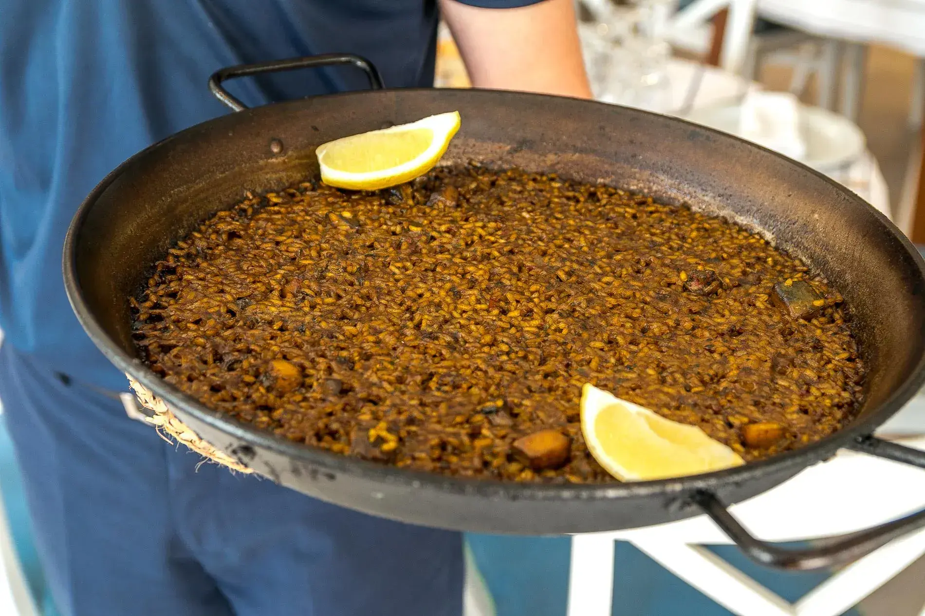 Port Balansat: Waiter holding a seafood paella