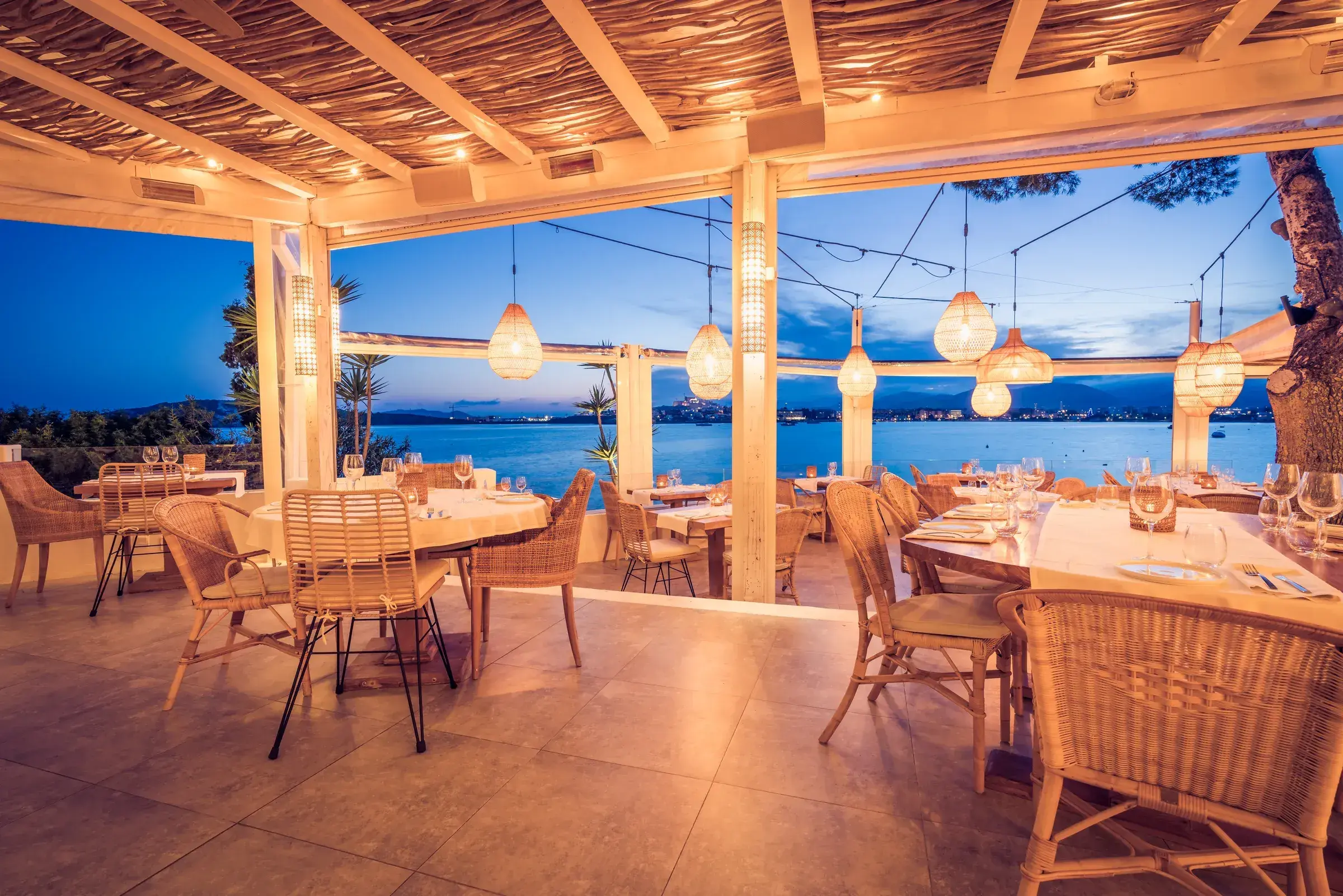 Sa Punta: Terrace at dusk with lanterns and Ibiza Town lights across the bay