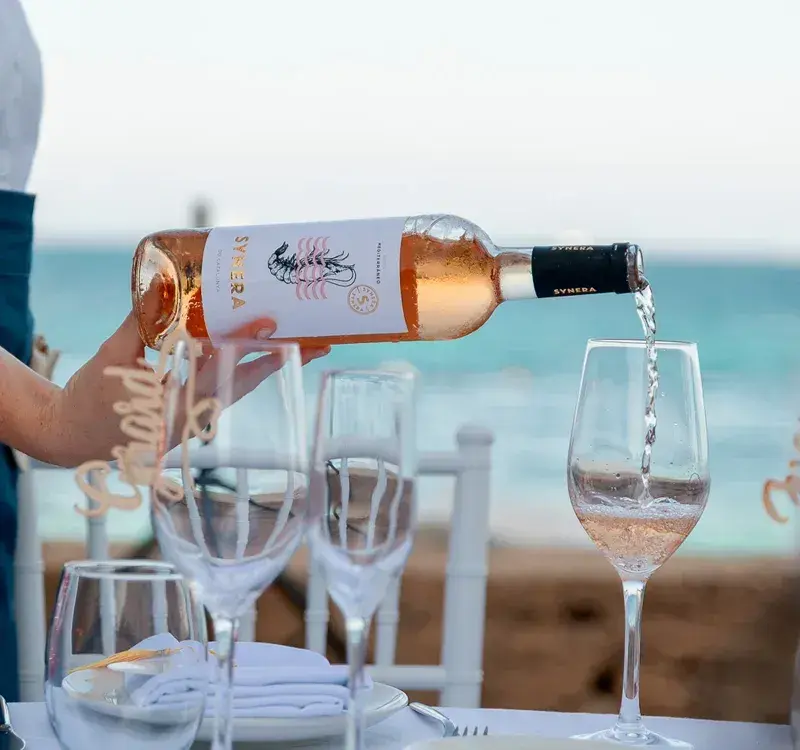 Seahorse Beach Club: Waiter pouring rosé at a table set by the sea