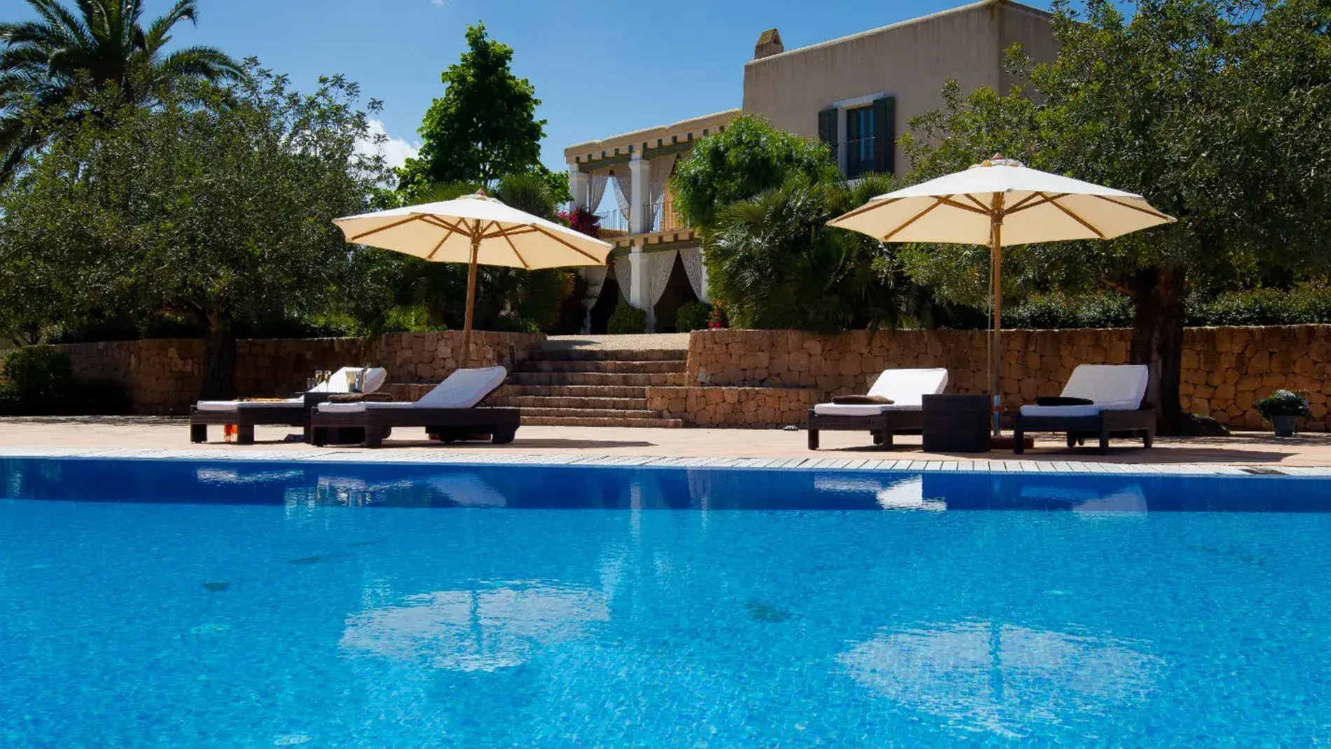 Villa Alex: Pool terrace with parasols in front of the stone house