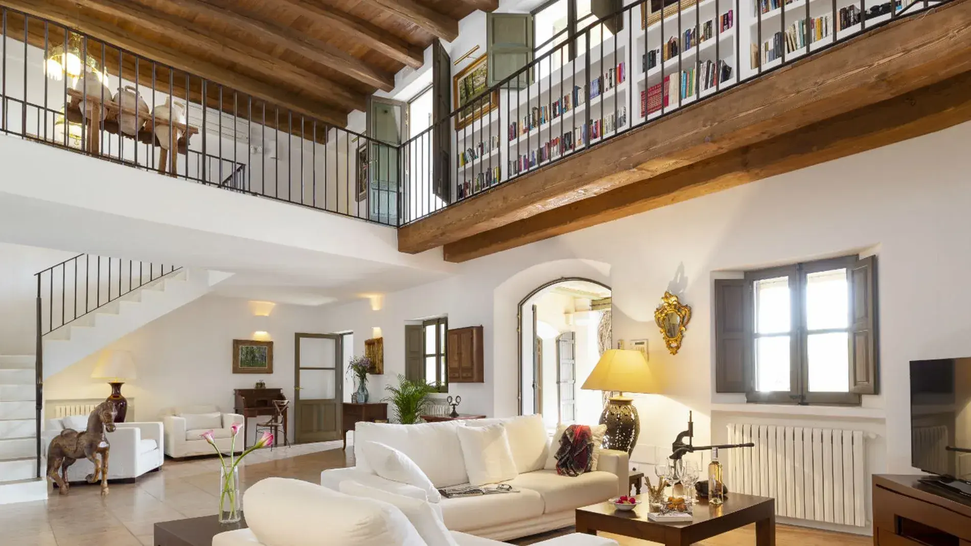 Villa Alex: Double-height living room with wooden beams and gallery