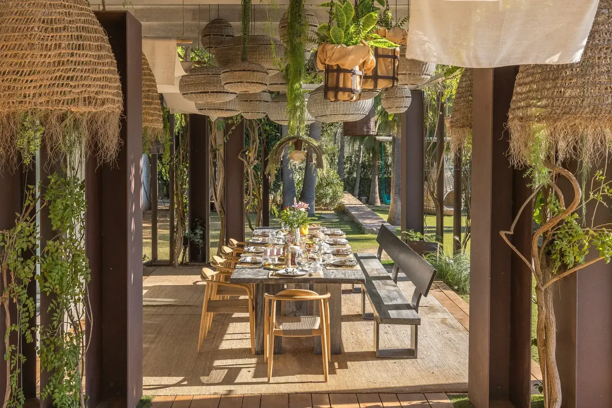 Villa Bliss Palm: Covered outdoor dining table under woven lamps and hanging plants