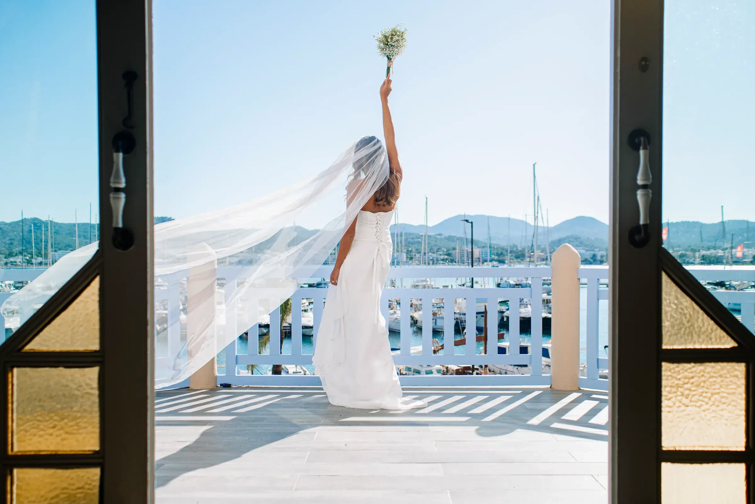 Villa Mercedes: Bride throwing her bouquet on the terrace with the marina behind