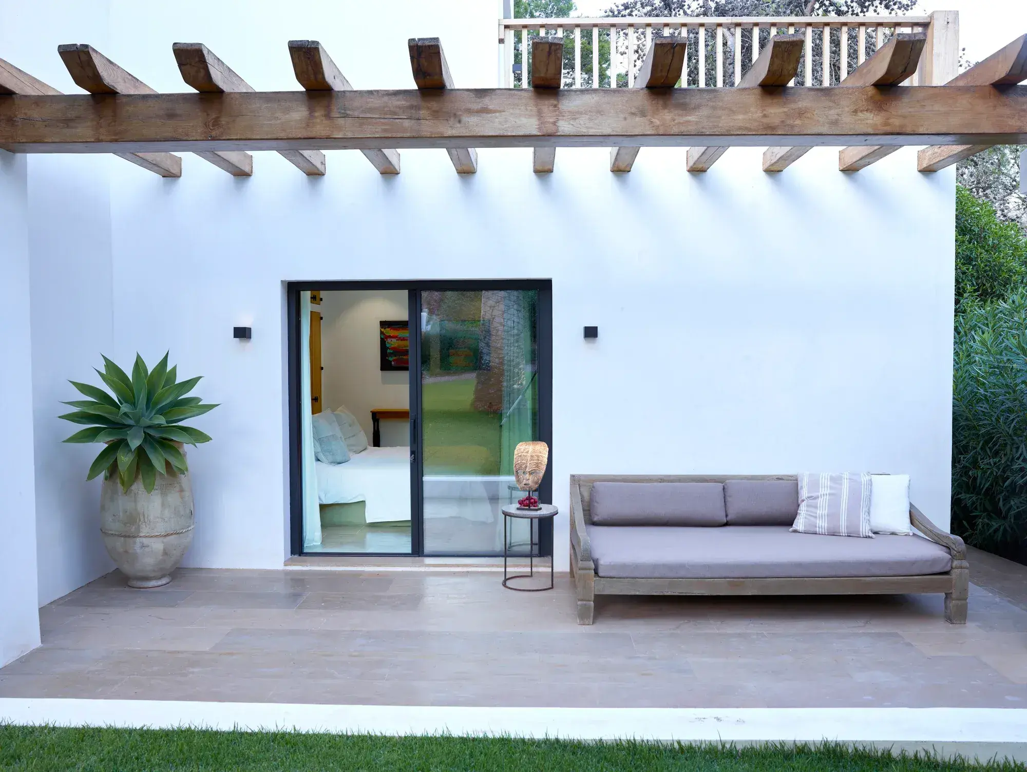 Villa Uma: Whitewashed guest house terrace with daybed and agave pot