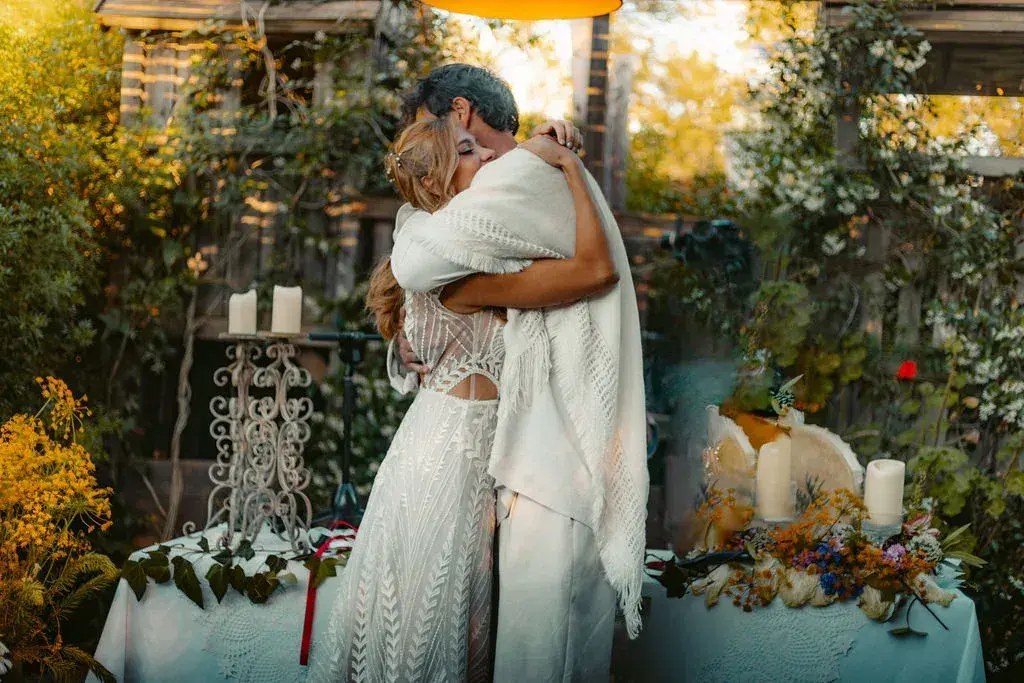 A mi Manera: Couple embracing beside a decorated table in the garden