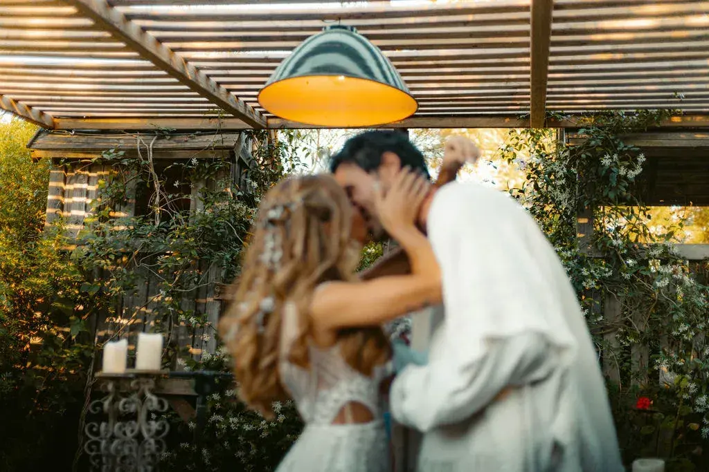 A mi Manera: Couple kissing under the pergola with hanging lamps