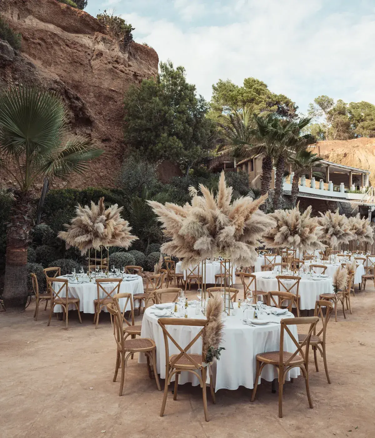 Amante Ibiza: Round wedding dinner tables with pampas-grass centrepieces on the cliff terrace