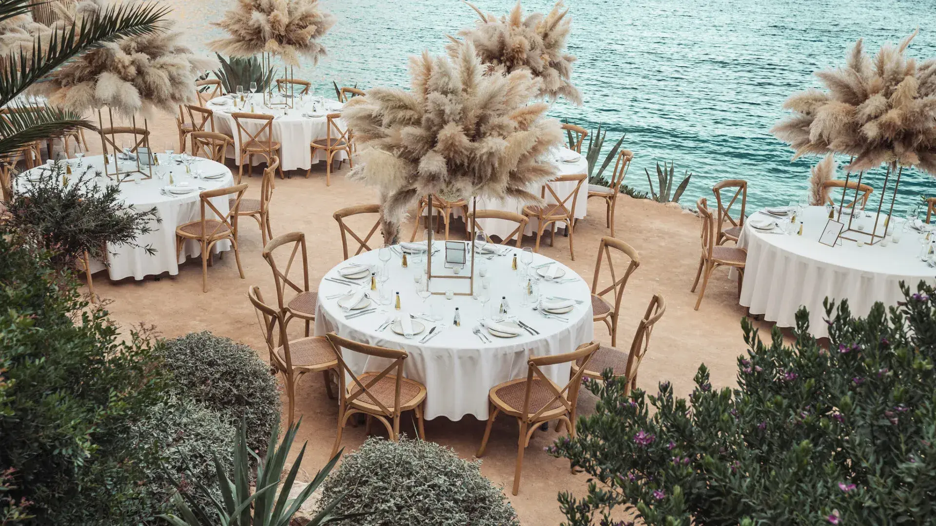 Amante Ibiza: Wedding reception tables with pampas arrangements overlooking the sea