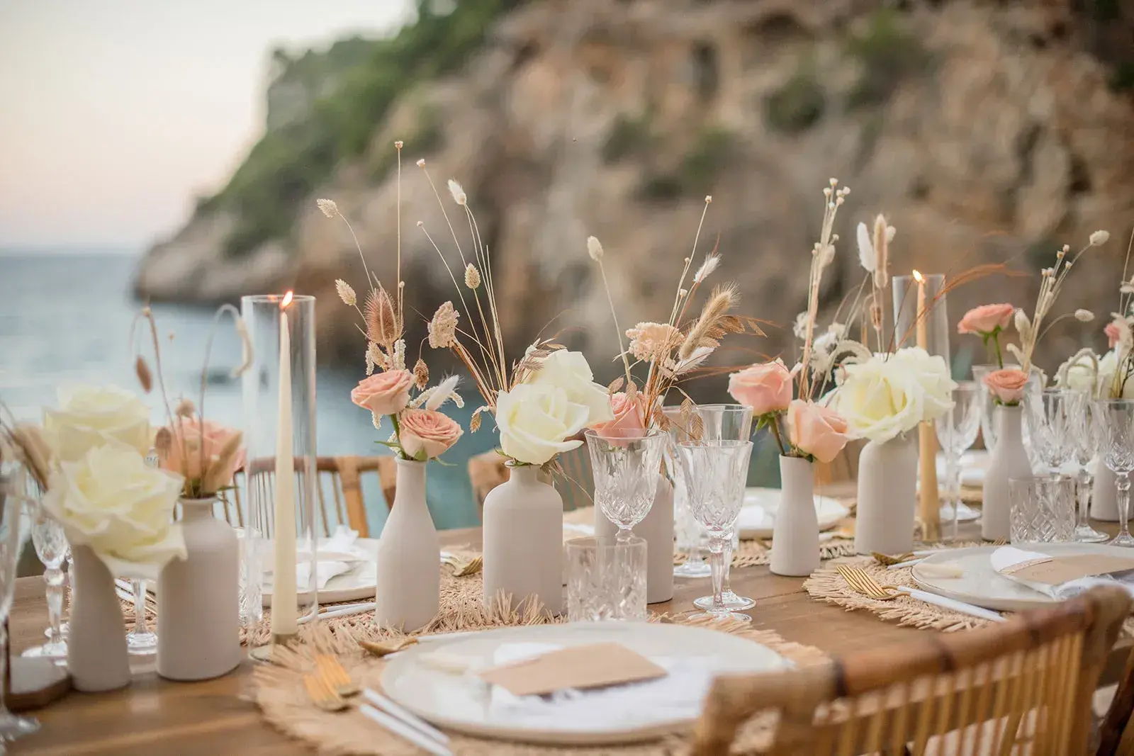 Amante Ibiza: Close-up of a wedding table with candles, dried flowers and white roses by the sea
