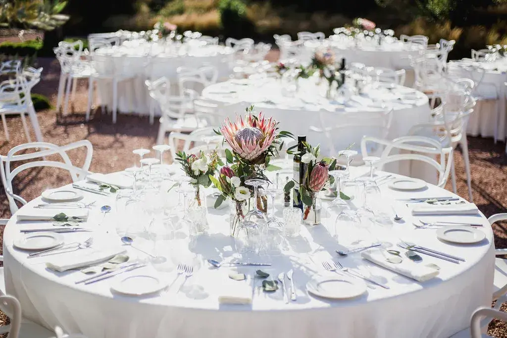 Ca Na Xica: Round tables with white linen and protea centrepieces