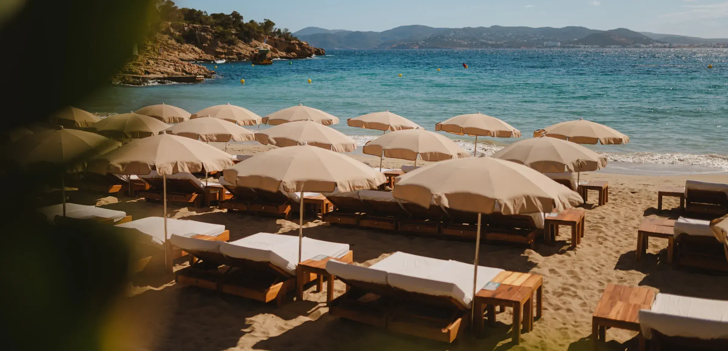 Cala Bassa Beach Club: Beige parasols and wooden sunbeds on Cala Bassa beach