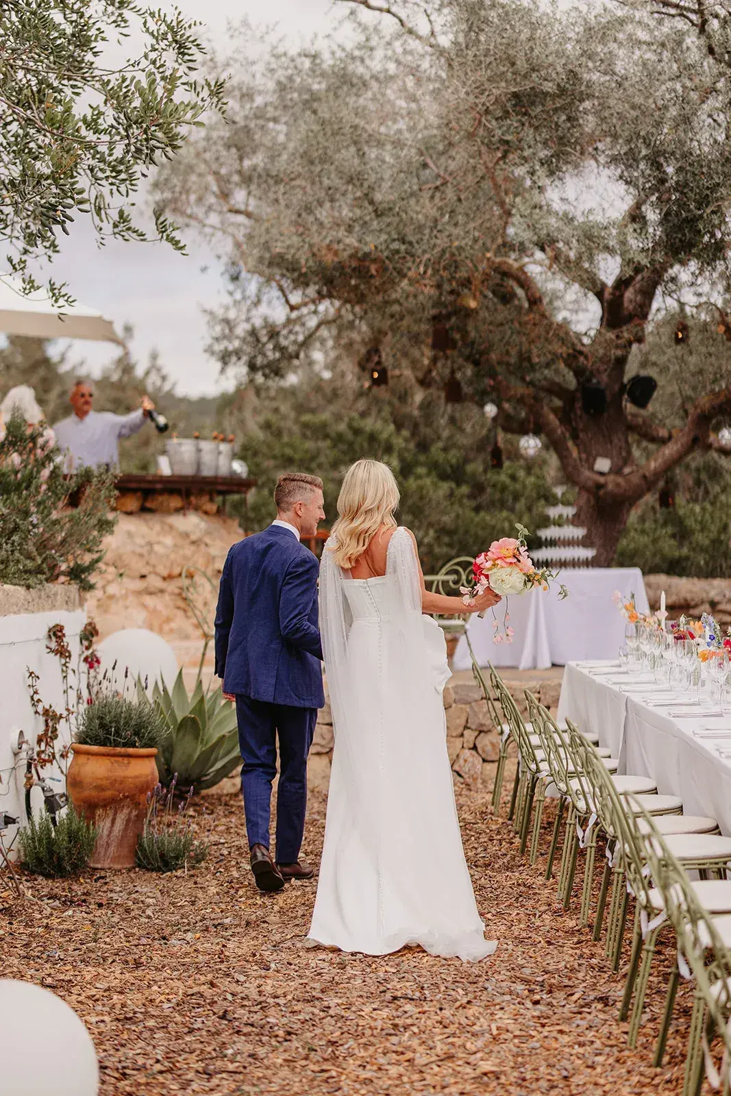 Couple walking up the aisle among olive trees at Can Domingo