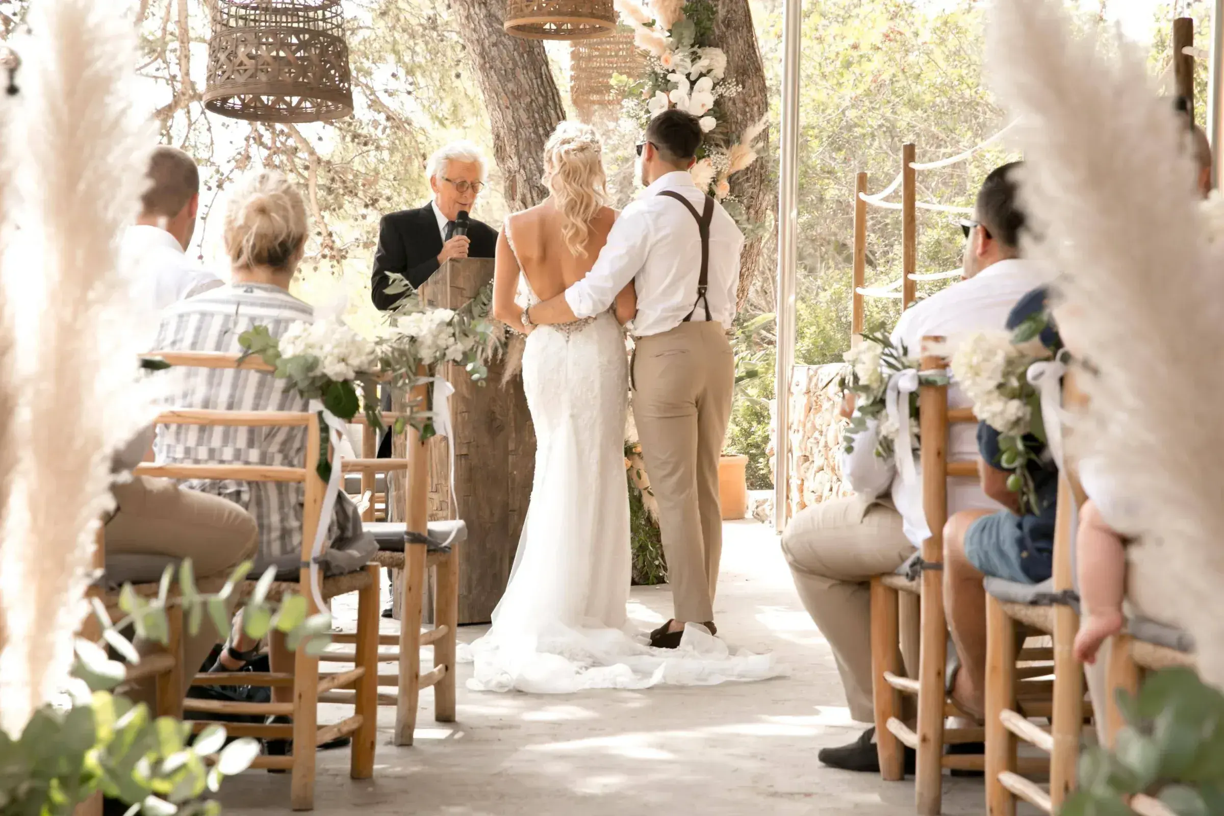 El Chiringuito Cala Gracioneta: Wedding ceremony under the pines with pampas grass and wooden chairs (file labelled 'Fran & Alex, Chiringuito Ibiza')