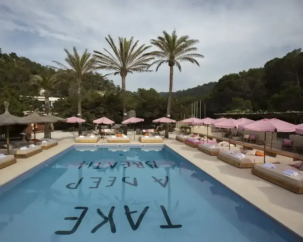 El Silencio: Pool deck with pink parasols, daybeds and palm trees