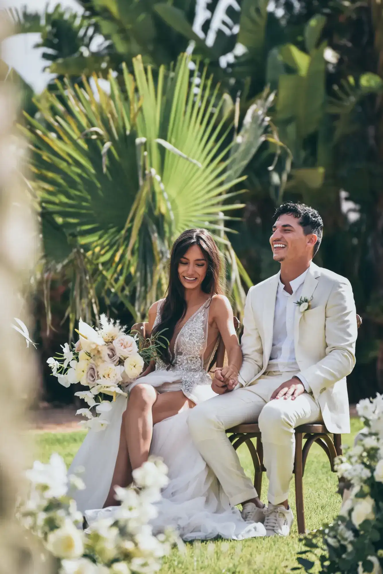 The couple seated under the palms