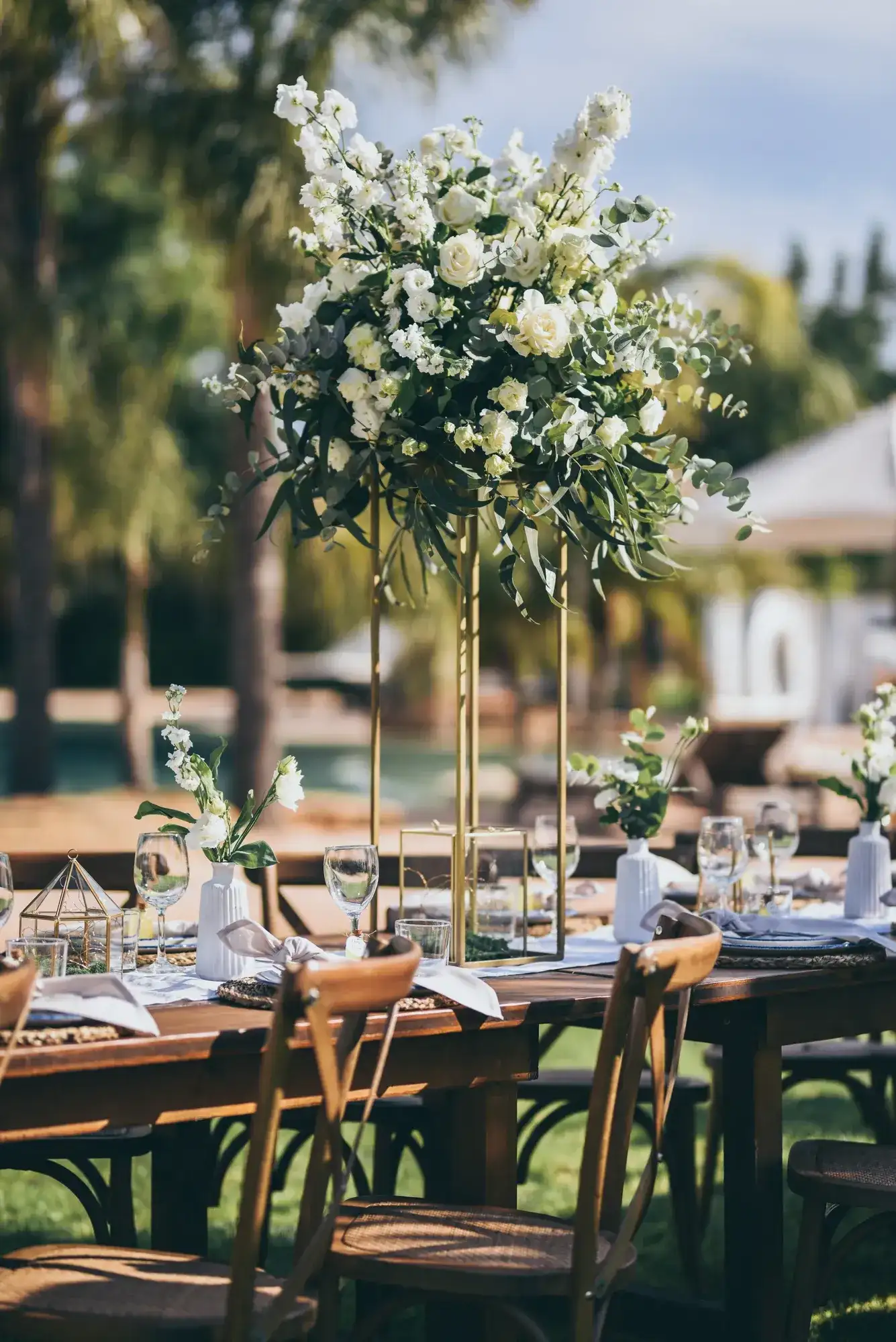 Tall white flowers over cross-back chairs