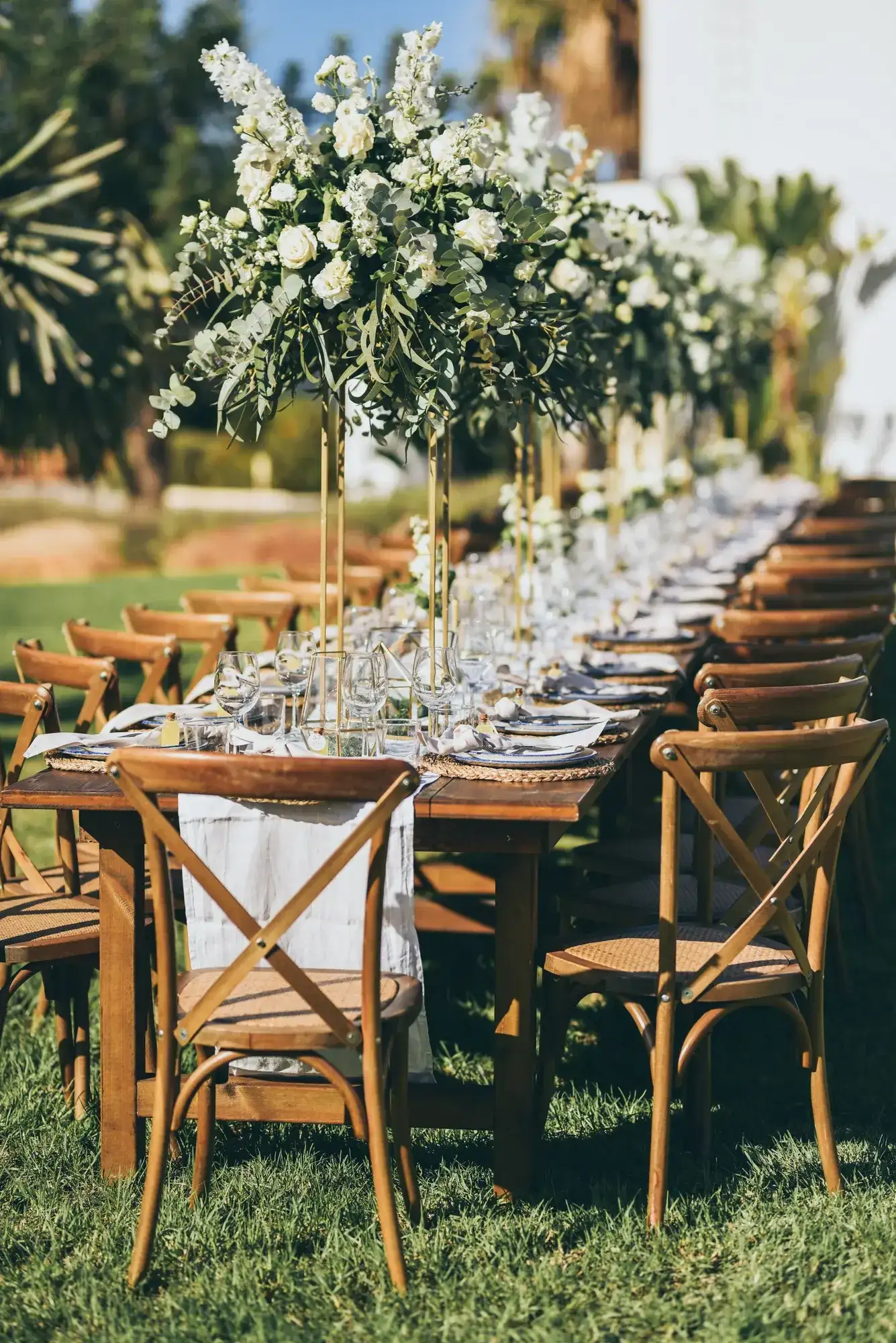 White flower towers over a long wooden table