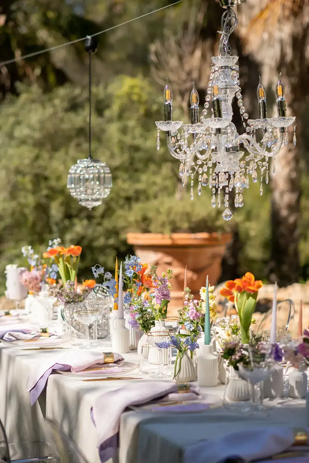 A chandelier over a colourful garden table, spring styled shoot