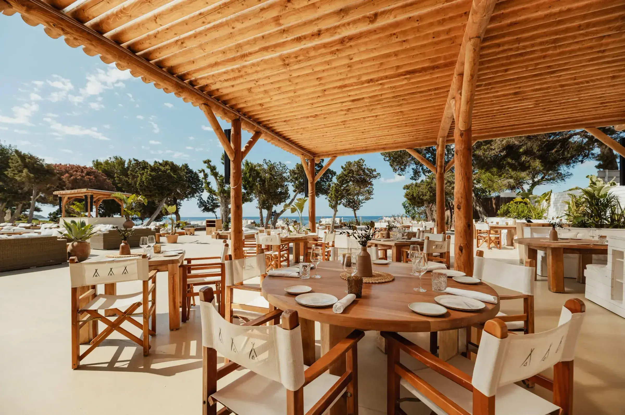 Nikki Beach Ibiza: Outdoor restaurant terrace under a timber pergola with set tables