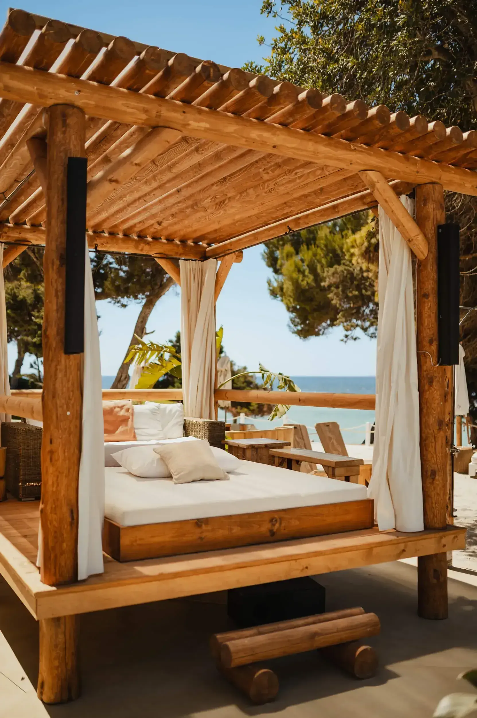Nikki Beach Ibiza: Wooden VIP cabana with white daybed and curtains
