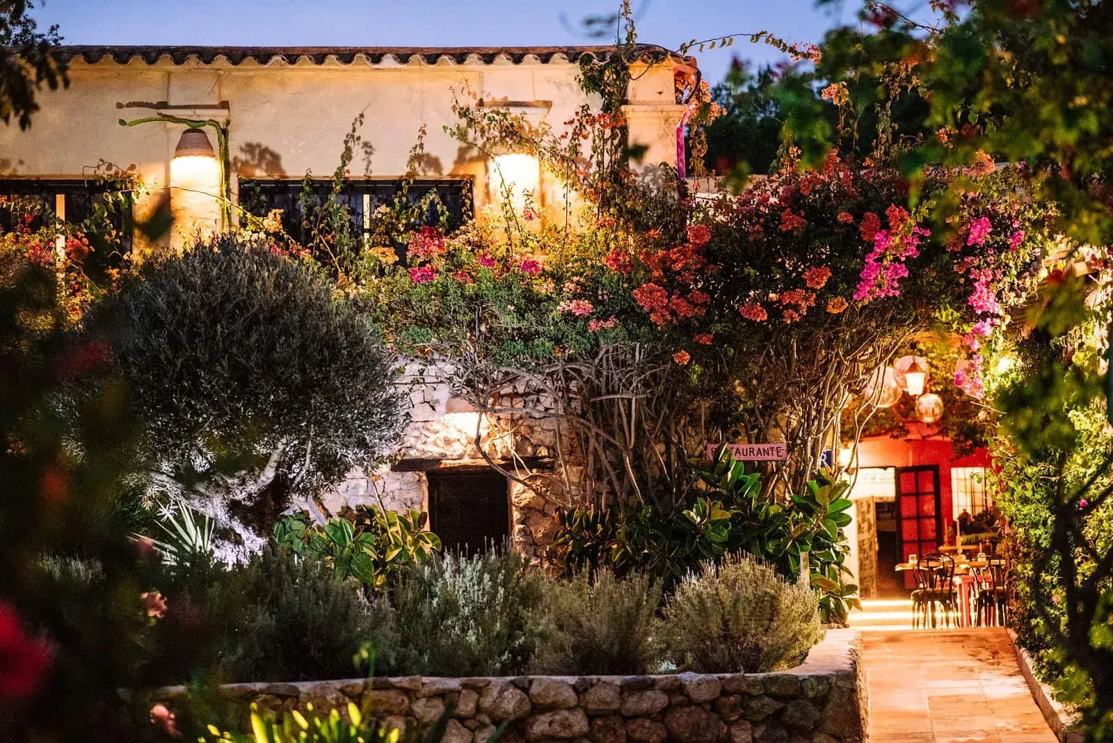 Pikes: Old finca buildings and garden lit up at dusk among flowers
