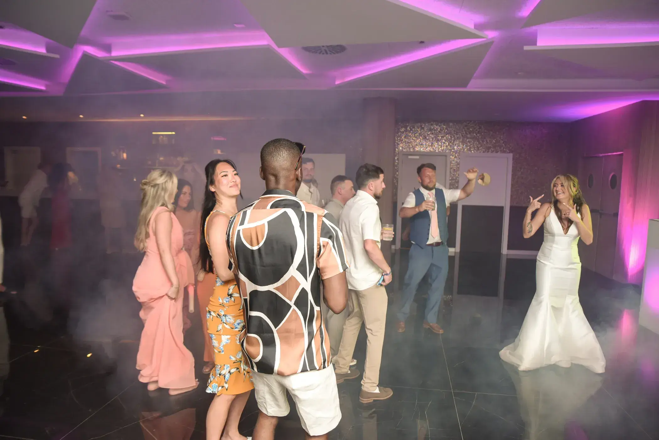 Torre del Mar: Bride and guests dancing in the indoor reception room with coloured lighting