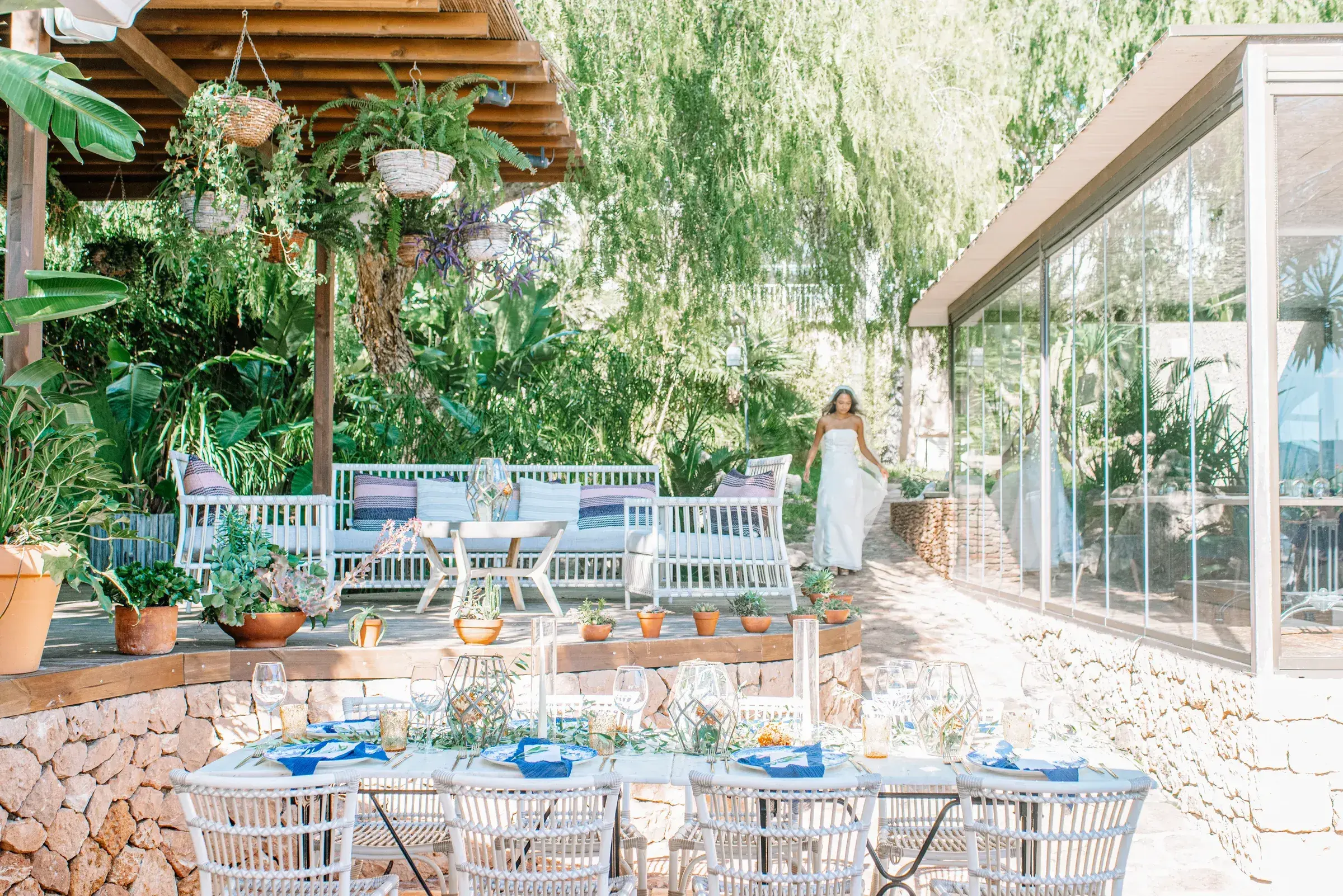 Villa Mercedes: Garden terrace with tables set for a wedding meal and a bride in the background